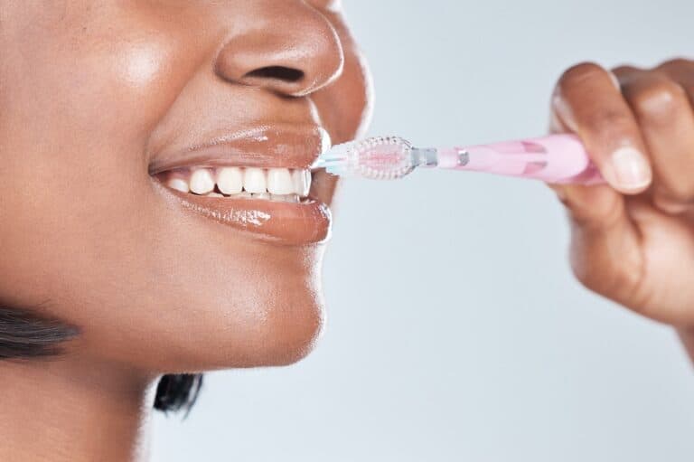 close up of a woman brushing her teeth and veneers